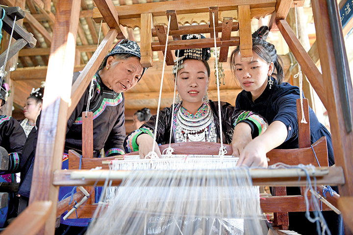 11月14日，楊成蘭（右）和兩位侗族婦女在貴州省榕江縣豐登侗寨倚山人織布染布手工技藝體驗館探討織侗布技藝。.JPG