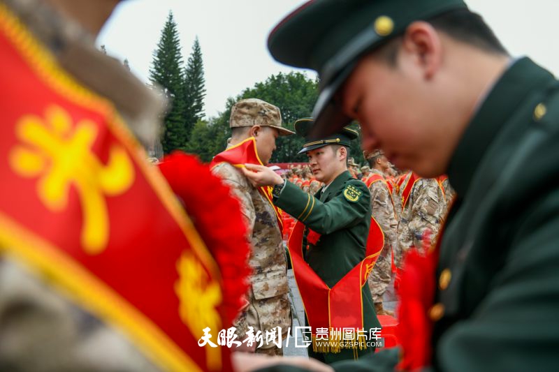 854108-3月15日，退伍老兵在貴州省黔西南布依族苗族自治州興義市萬峰林景區(qū)將軍峰廣場給新兵戴綬帶。.jpg