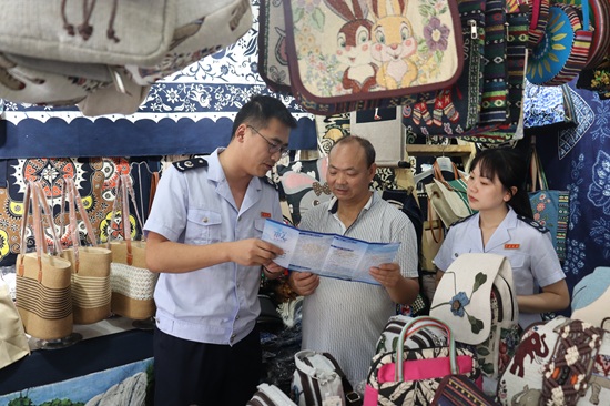 安順市鎮(zhèn)寧縣稅務(wù)局干部走進(jìn)景區(qū)紀(jì)念品店為納稅人介紹最新稅費(fèi)優(yōu)惠政策（拍攝：舒開(kāi)培）.jpg