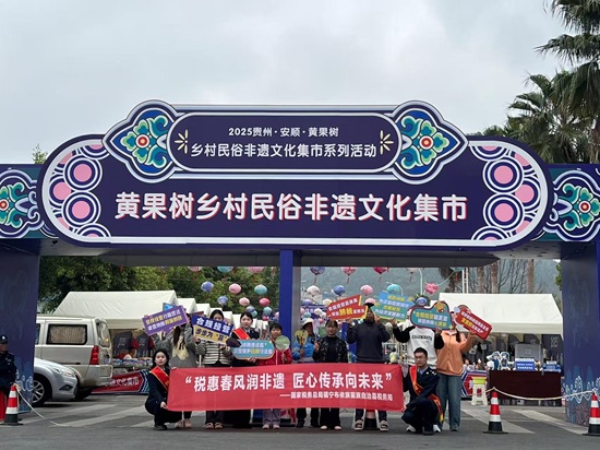 鎮(zhèn)寧布依族苗族自治縣稅務(wù)局“非遺稅惠服務(wù)小分隊”走進(jìn)黃果樹鄉(xiāng)村民俗文化集市，以稅力量”守護(hù)好非遺傳承人的“匠心”。（董茹蕓 攝）.jpg