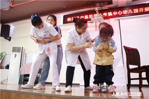 图为：2025.05.27榕江县中医院医护人员正在为老师和学生现场手把手教老师海姆立克急救法实操.jpg