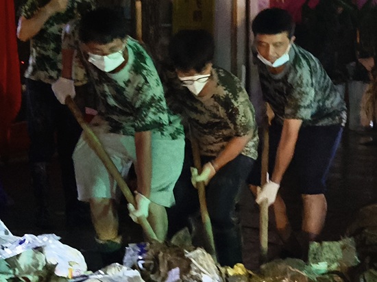 榕江縣稅務(wù)局青年干部黃綠川（中間）連夜投入搶險清淤工作.jpg