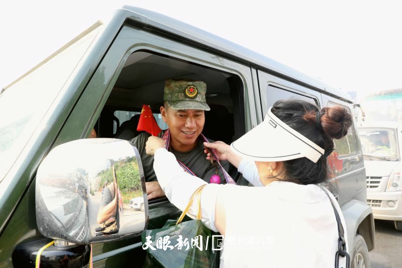 892190-2025年7月8日，在贵州省黔东南苗族侗族自治州榕江县车民街道，一名妇女将红鸡蛋和鞋垫赠送给抗洪抢险救援返程的民兵。.jpg