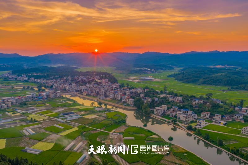 898111-7月27日，黔東南苗族侗族自治州錦屏縣新化鄉(xiāng)新化所村，夕陽西下，激起漫天晚霞，民居與河流、田野及遠山相映生輝。.jpg