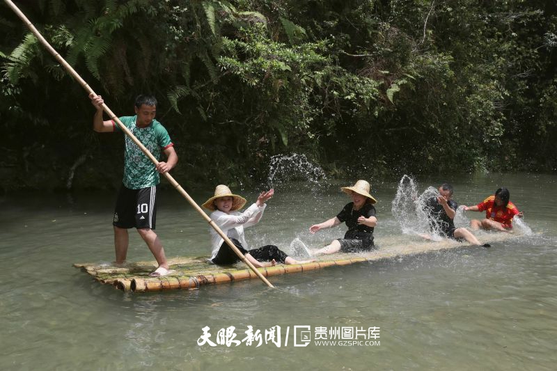 895535-2025年7月19日，在貴州省黔東南苗族侗族自治州榕江縣水尾水族鄉(xiāng)拉術(shù)村水上娛樂(lè)旅游點(diǎn)，人們?cè)趧澲衽艖蛩{涼。.jpg