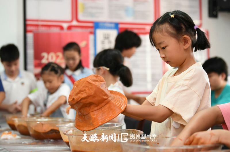901282-8月6日，在貴陽市南明區(qū)油榨街道梅子留香泥土染手工活動現(xiàn)場，一位小朋友正在制作非遺泥染手工作品。.jpg