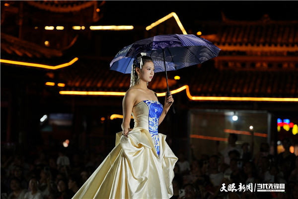 dD0xNzU5NzAzOTU0X3I9NmViODE1MzZfdz02MDBfcT0xMDBfZT1qcGc=.webp 首届贵州“村T”民族时装周文创设计大赛成果展上,一名模特正在展示文创作品.jpg