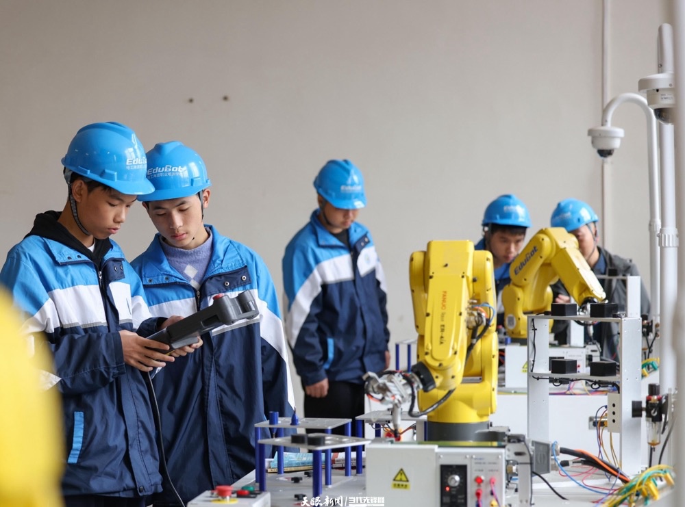 dD0xNzYzNTIzNjQwX3I9NDQyOWIxMTBfdz0xMDAwX3E9MTAwX2U9anBn.webp 贵州省铜仁市玉屏侗族自治县中等职业学校的学生在进行工业机器人实操。胡攀学 摄.jpg