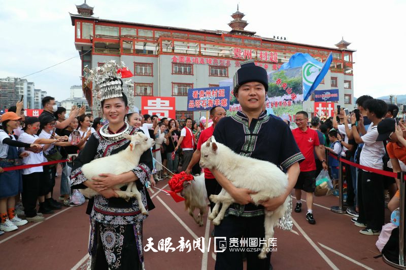 dD0xNzYzNjg3MDk1X3I9YWRlMGQ3ZWRfdz04MDBfcT0xMDBfZT1qcGc=.webp 图9:2023年6月17日,在贵州省黔东南苗族侗族自治州榕江县城北新区足球场,塔石乡瑶族群众抱着生态养殖的地理标志产品香羊入场。.jpg