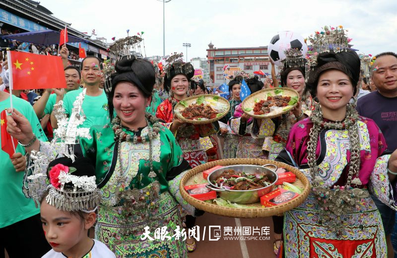 dD0xNzYzNjg3NDI0X3I9NDUyYTY5YTJfdz04MDBfcT0xMDBfZT1qcGc=.webp 图1:2023年7月1日,在贵州省黔东南苗族侗族自治州榕江县城北新区足球场通道,来自乐里镇小瑞村足球队的啦啦队身着盛装、端着美食入场,吸引众多球迷的眼球。.jpg