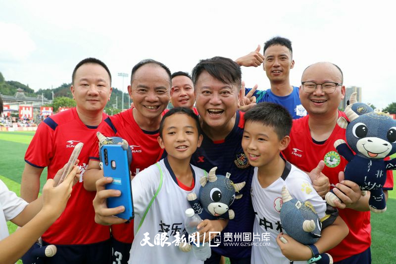 dD0xNzYzNjg4MDU5X3I9ZjBhZjE2NWZfdz04MDBfcT0xMDBfZT1qcGc=.webp 图12:2023年8月13日,在贵州省黔东南州苗族侗族自治州榕江县城北新区足球场,榕江村民队球员与香港明星足球队陈百祥合影纪念。.jpg