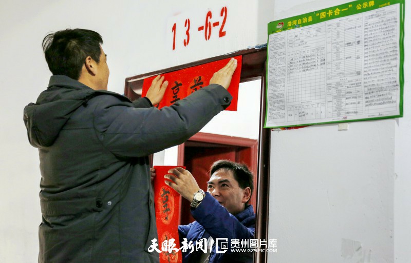 117669-图为冉勇在该县县城思州易地扶贫搬迁安置房张贴春联。.jpg