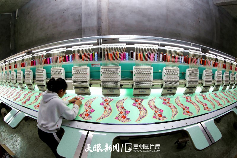 687616-2023年12月15日，工人在贵州省黔东南苗族侗族自治州榕江县忠诚镇一家侗族绣花厂的绣片生产车间赶制刺绣订单产品。.jpg