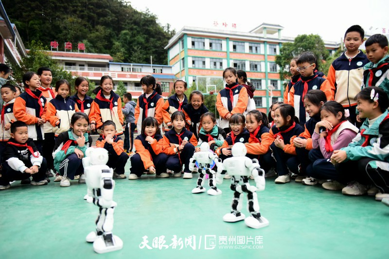 926487-2025年10月23日，学生在贵州省黔东南苗族侗族自治州从江县城关第三小学参观机器人表演展示。.jpg