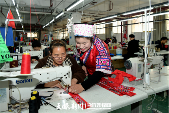 黔东南州、凯里市人大代表杨美在制衣车间指导工人刺绣.png