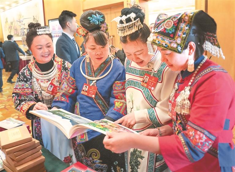 全国人大代表杨恩兰（左一）、杨再滔（左二）、杜薇（右二）、卢丹（右一）翻看“我们的‘十四五’·贵州新风采”2026全国两会贵州图片展配套画册。.jpg