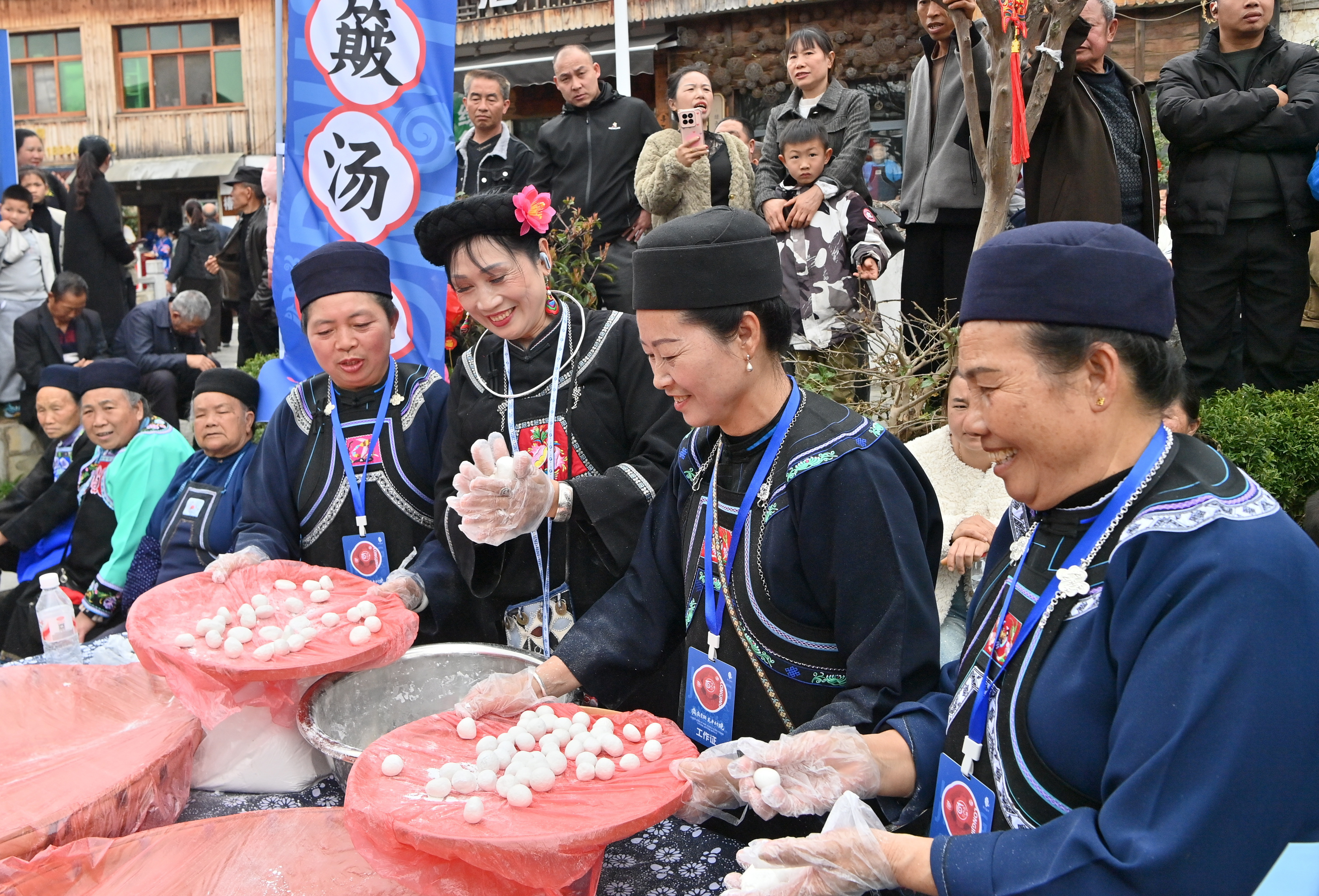 963599-在花溪区龙井村，布依族女孩在为游客展示簸汤圆民俗。乔啟明摄.JPG