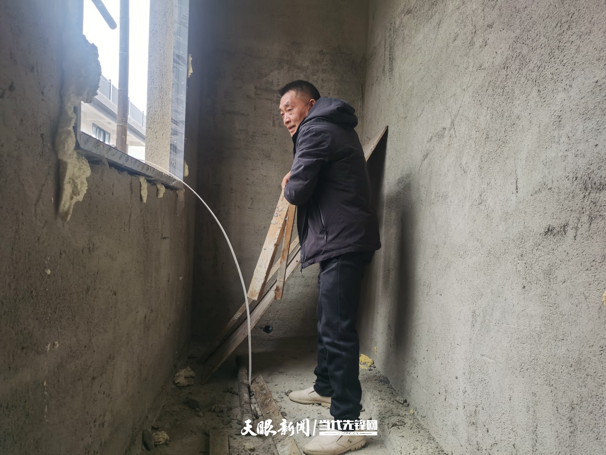 郭贵忠正在收拾屋子.jpg