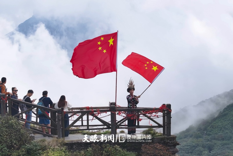1037064-9月28日，梵净山云雾缭绕，游客在观景台手持五星红旗，洋溢着热烈喜庆的节日氛围。图为无人机拍摄。.jpg
